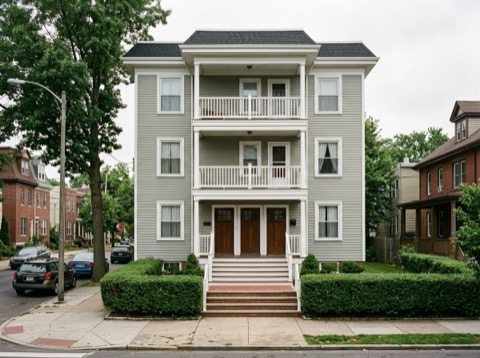 1119 Monroe Street NE, a pale green house with stacked porches